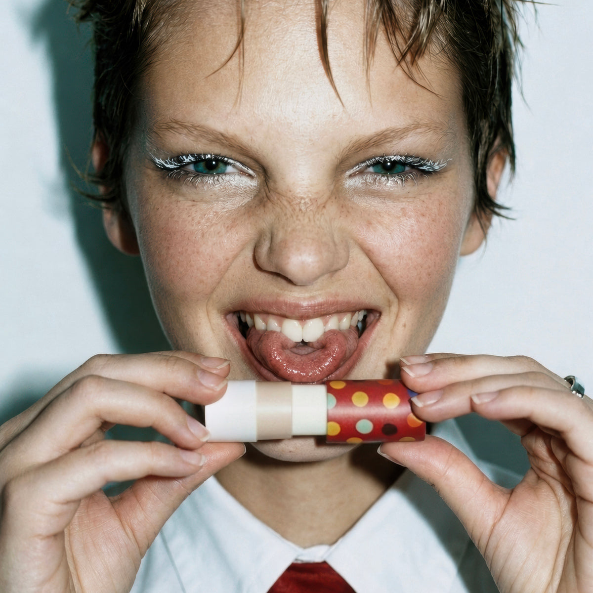 Model holding Zarbi Banana Bubble Gum vegan lip balm in colorful paper packaging.